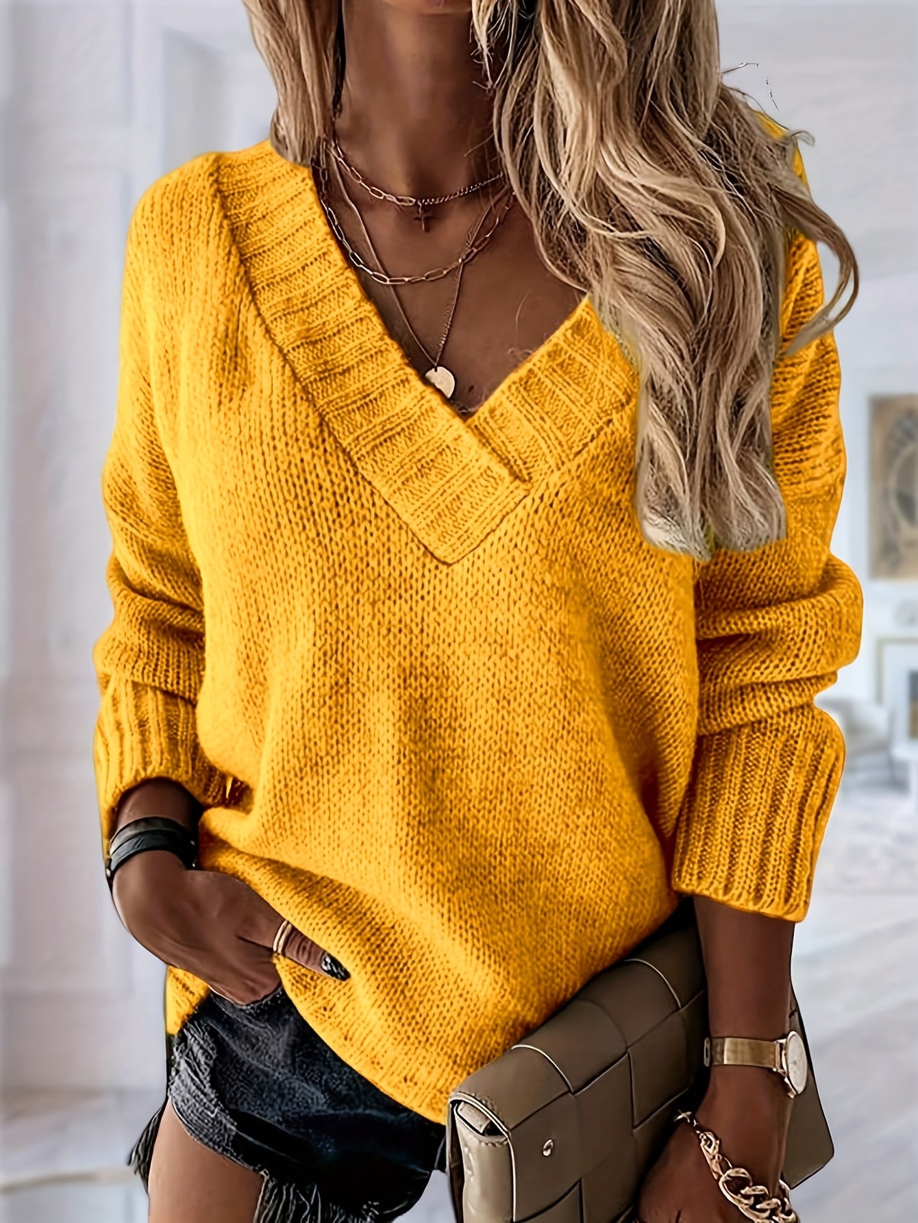 Woman wearing a yellow sweater with a blurred indoor background