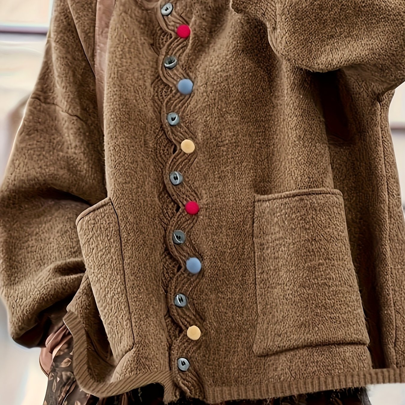 Brown fleece jacket with colorful buttons on a blurred background