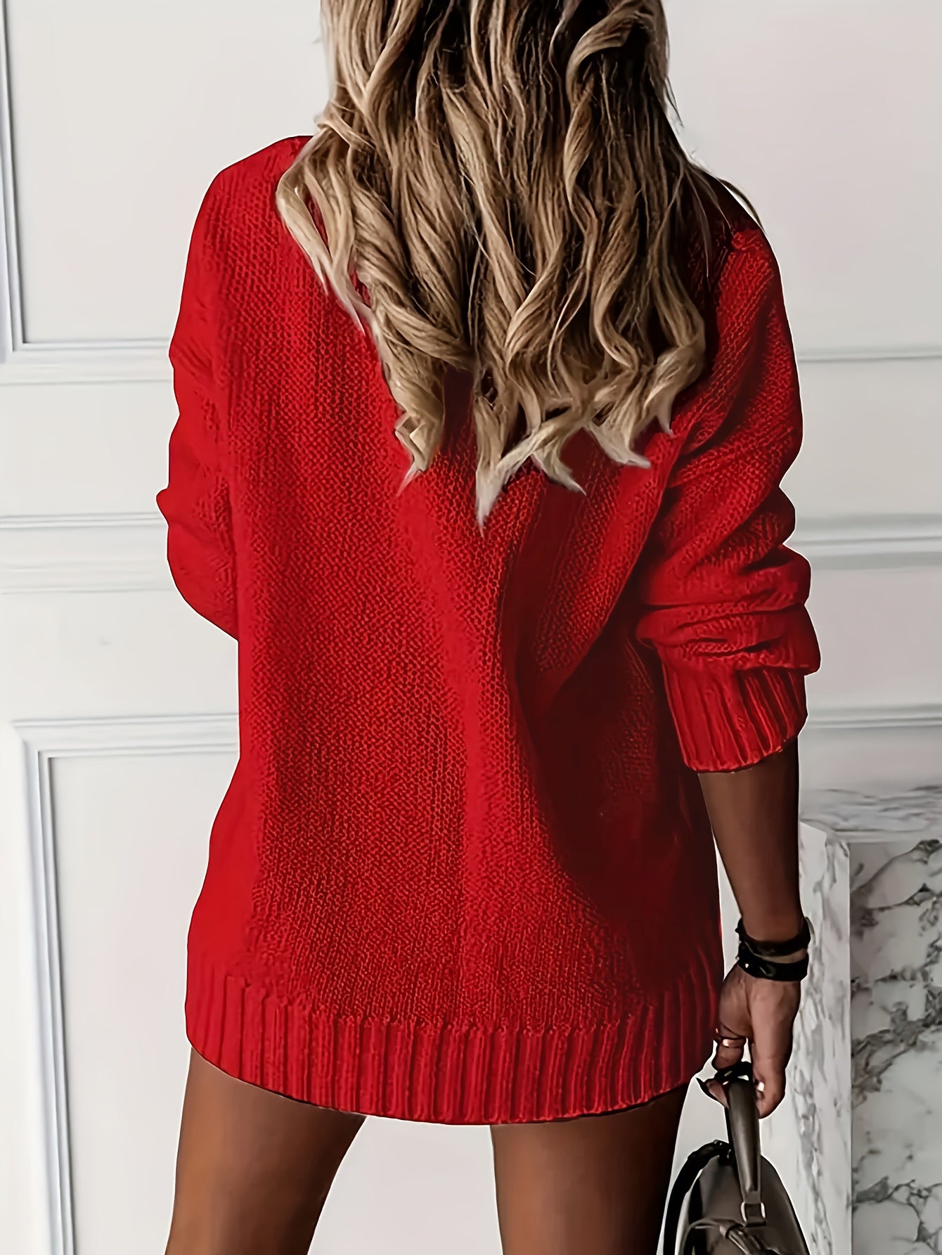Person wearing a red sweater dress with a blurred background