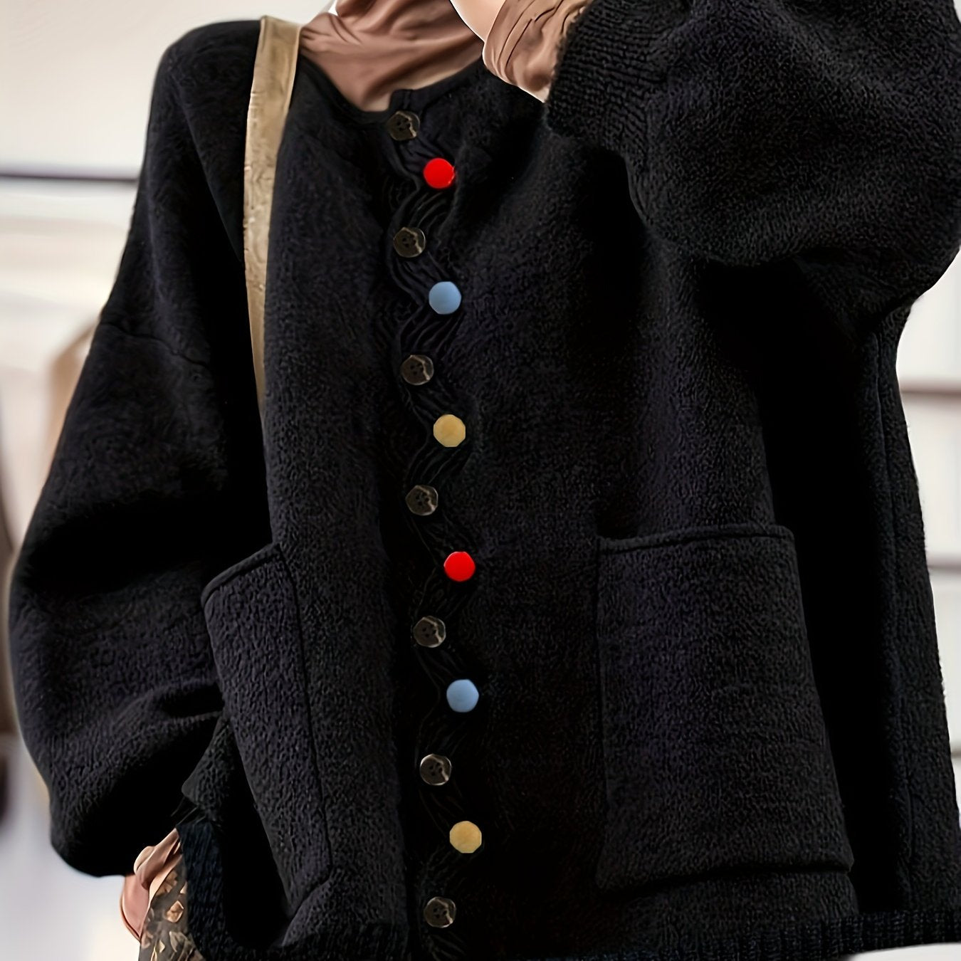 Black coat with colorful buttons worn by a person, blurred background