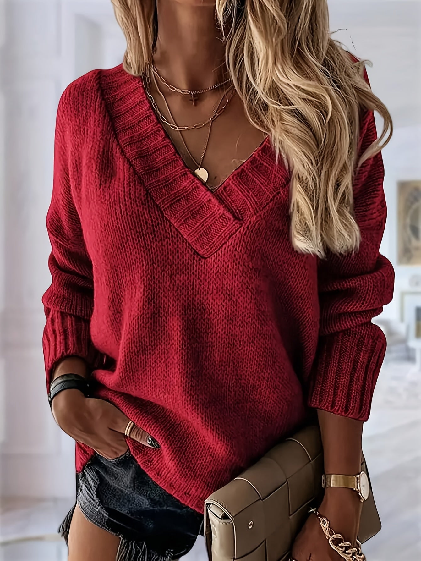 Person wearing a red sweater with a blurred indoor background