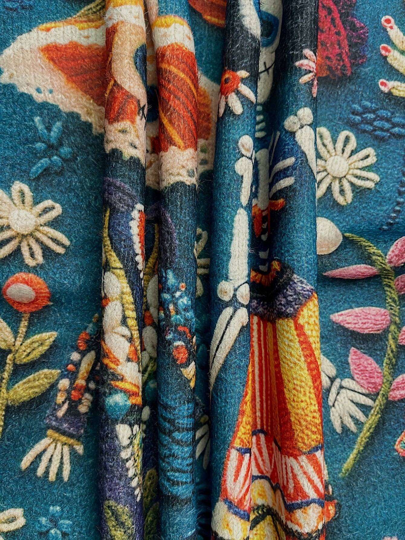 Close-up of colorful embroidered fabric with floral and abstract patterns.