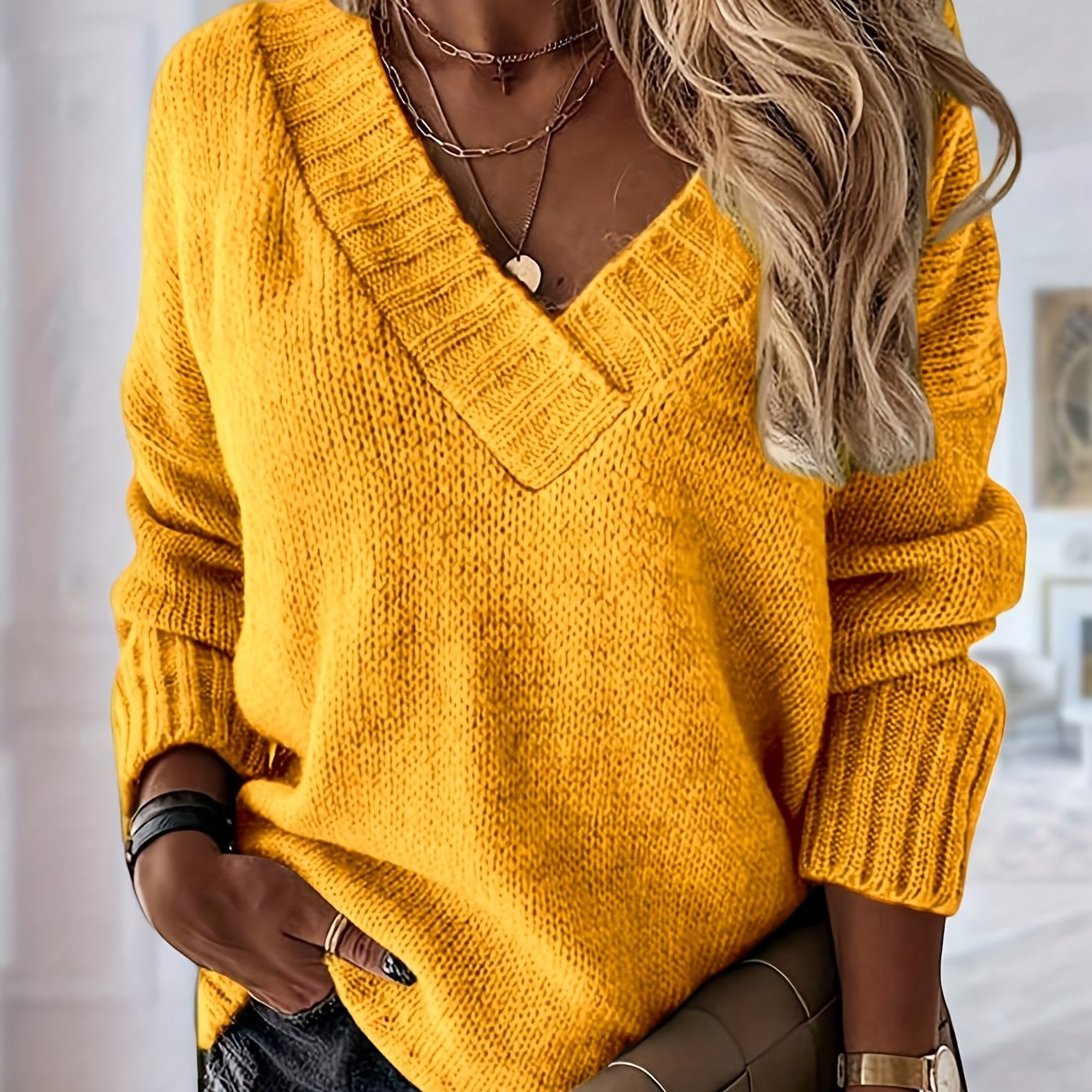 Yellow knitted sweater worn by a person with a blurred background