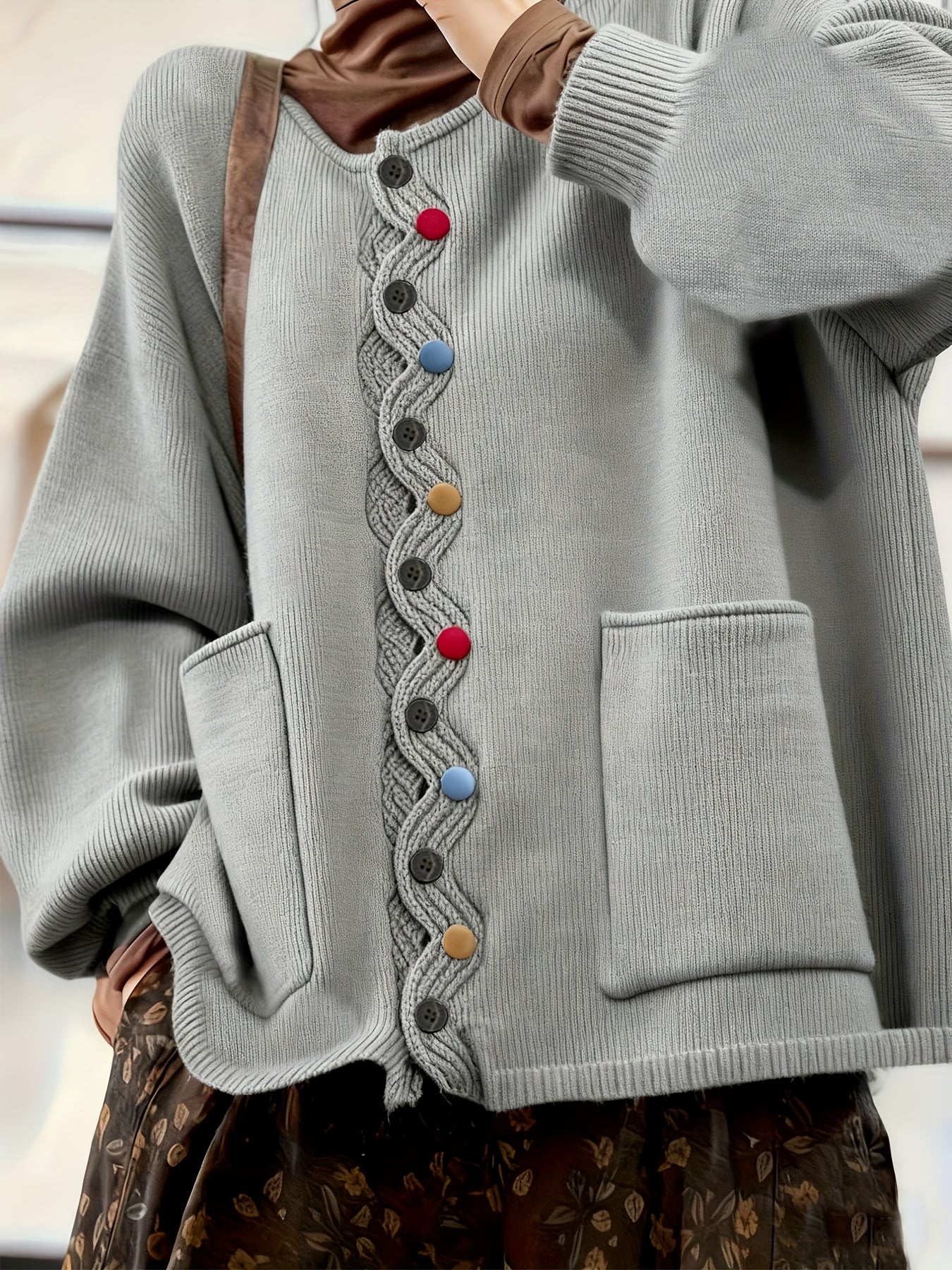 Gray sweater with colorful buttons on a neutral background