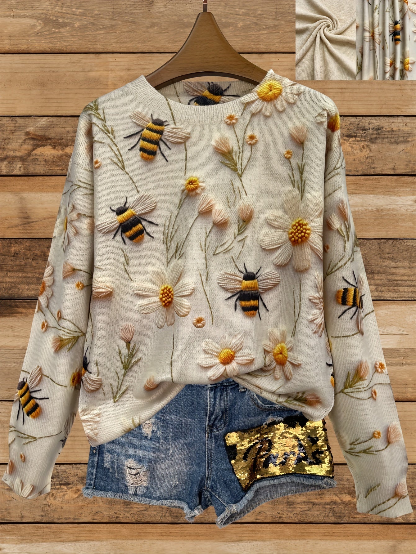 Floral and bee-patterned sweater on a wooden background