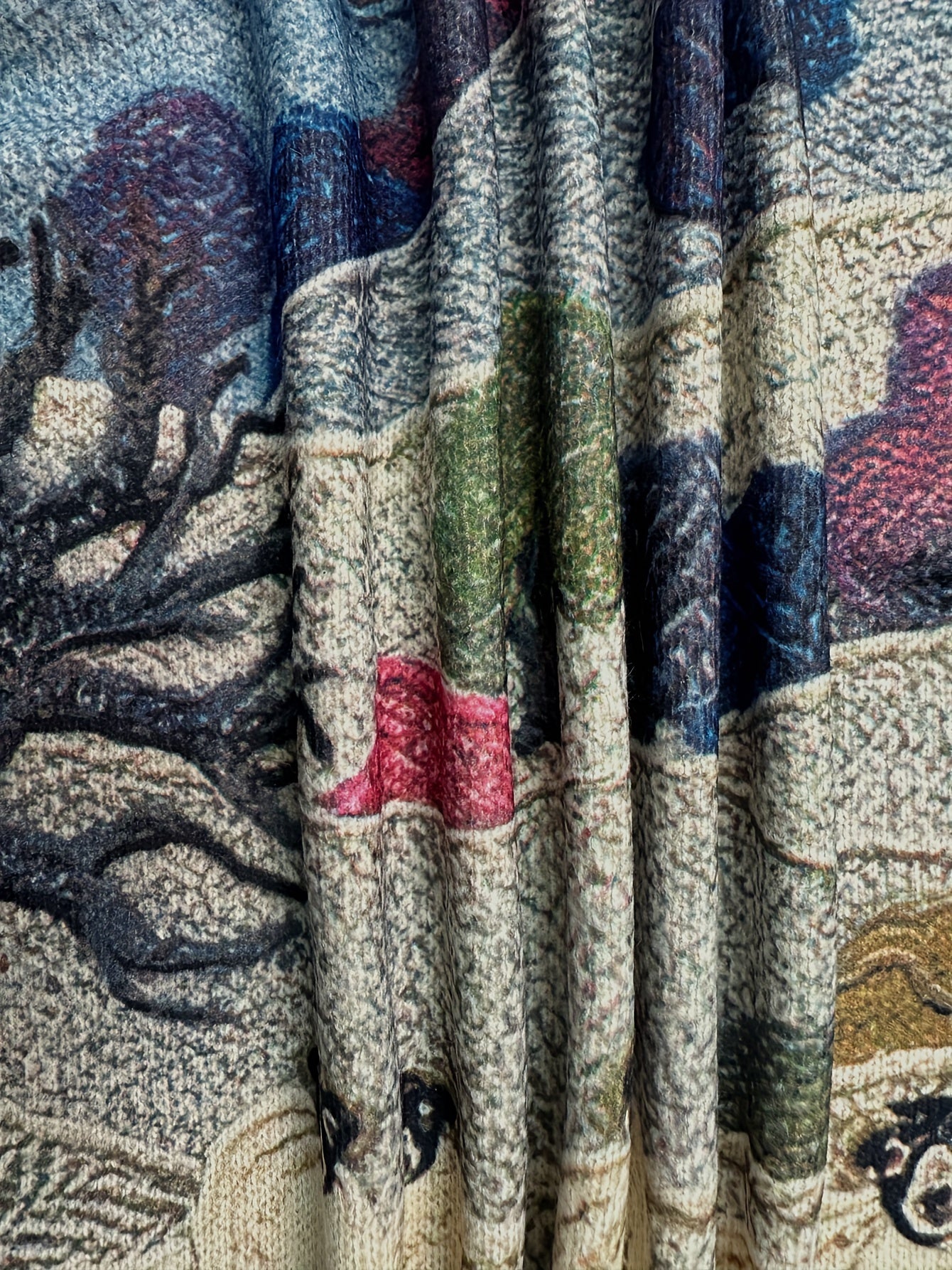 Close-up of a textured fabric with a nature-themed design featuring trees and animals.