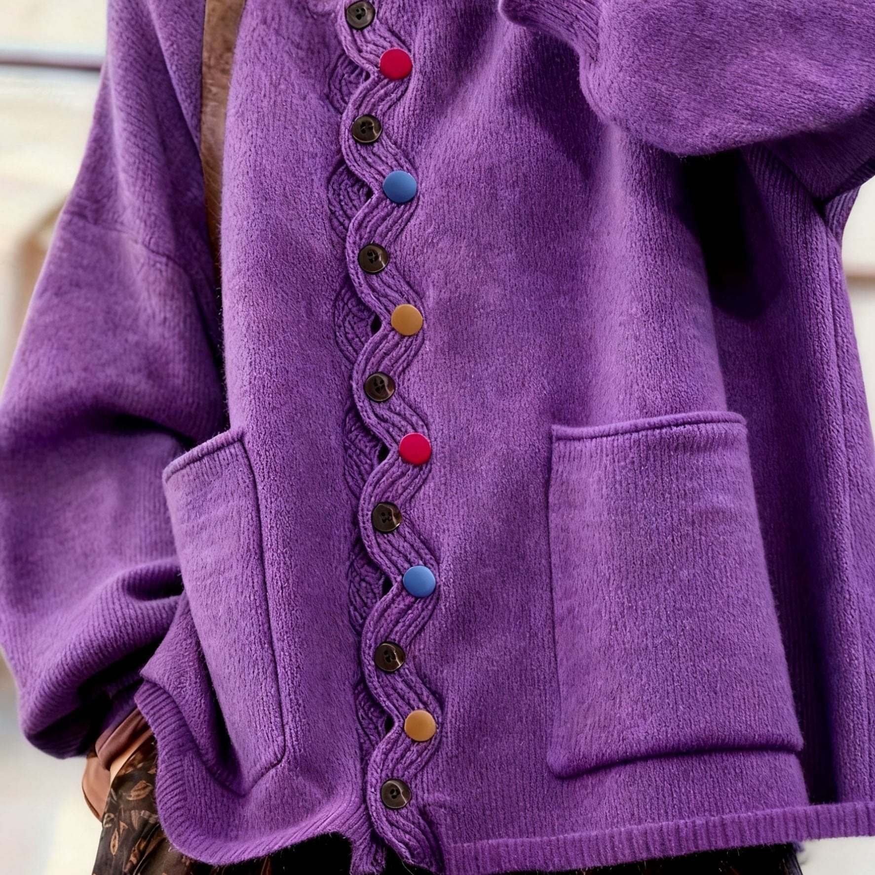 Close-up of a purple cardigan with colorful buttons on a blurred background