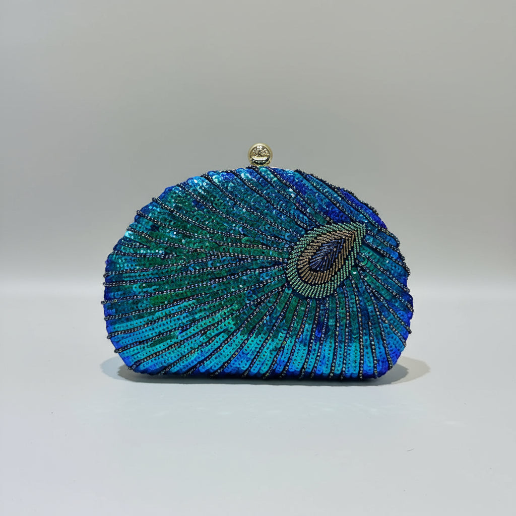 Blue and green beaded clutch held by a hand on a light background