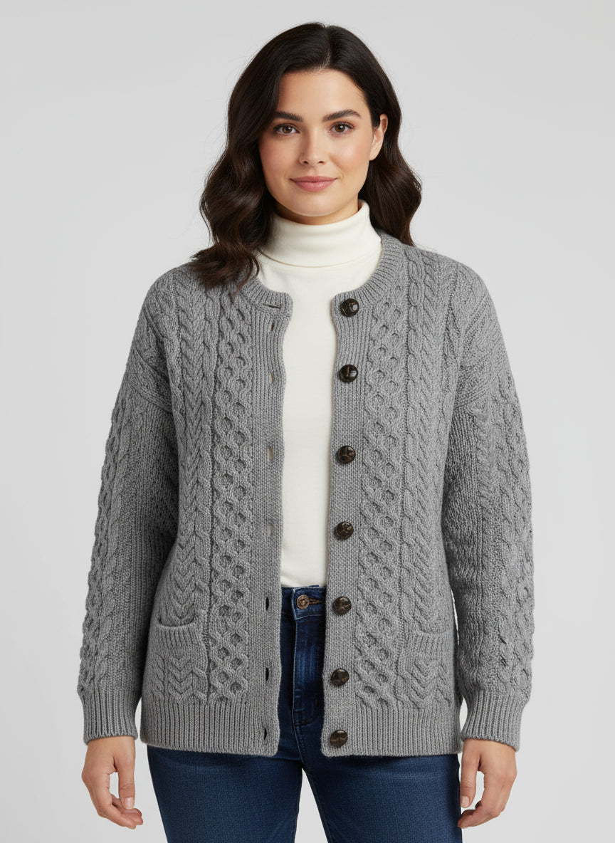 Person wearing a gray cable knit cardigan with buttons.
