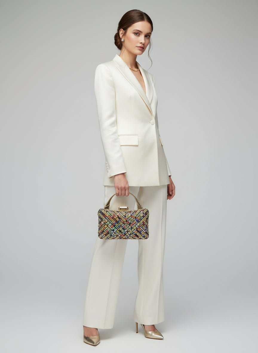 Multicolored beaded handbag held by a person against a neutral background