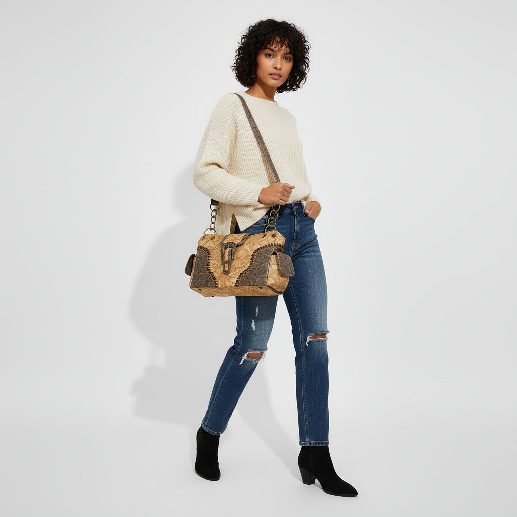 Person holding a decorative handbag with intricate patterns on a plain background