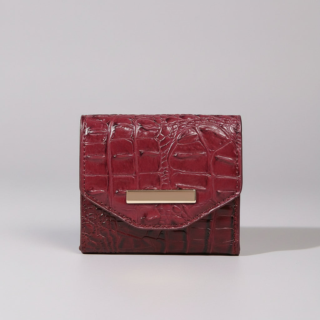 Red textured wallet with a gold clasp on a light surface, with a close-up of fabric texture in the corner.