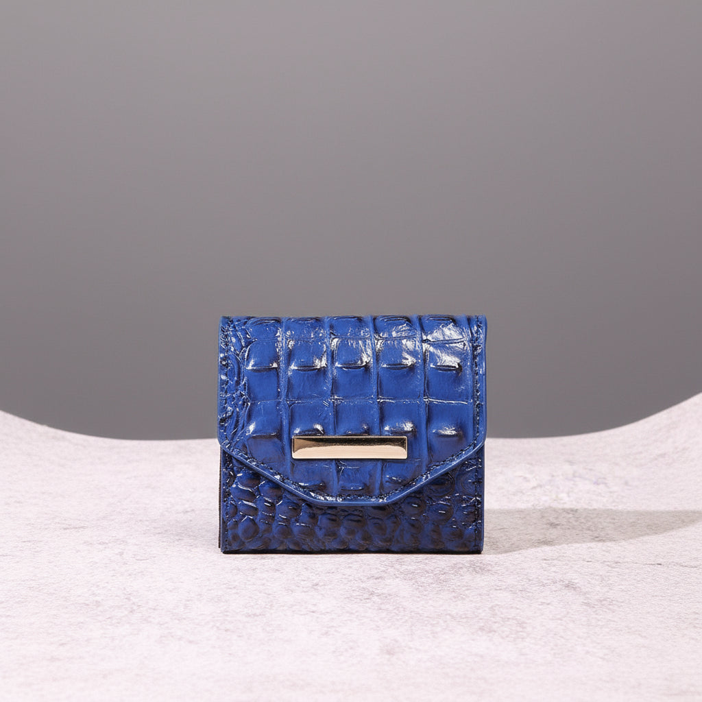 Blue textured wallet with a gold clasp on a light pink surface.