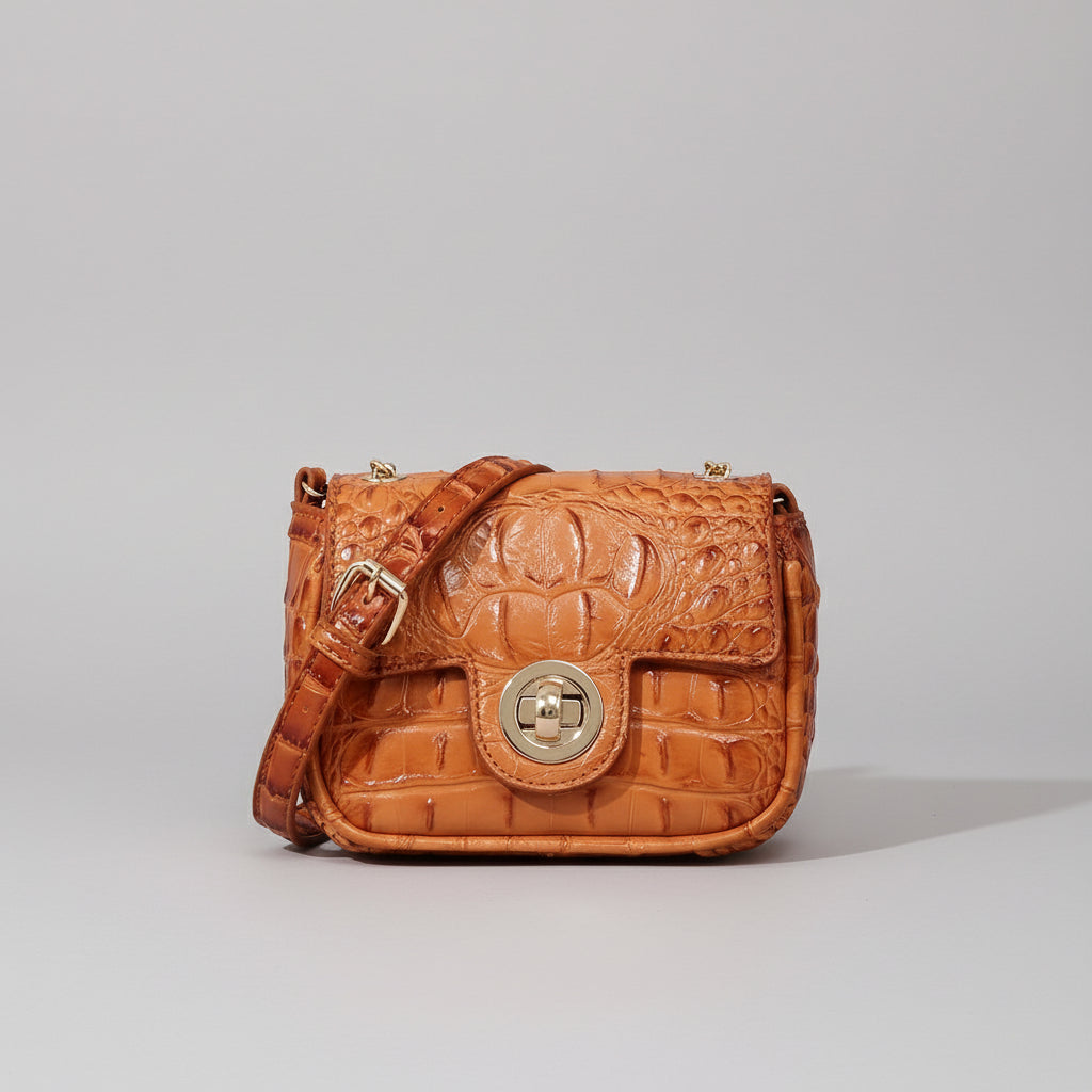 Brown textured handbag on a wooden surface with a dark background