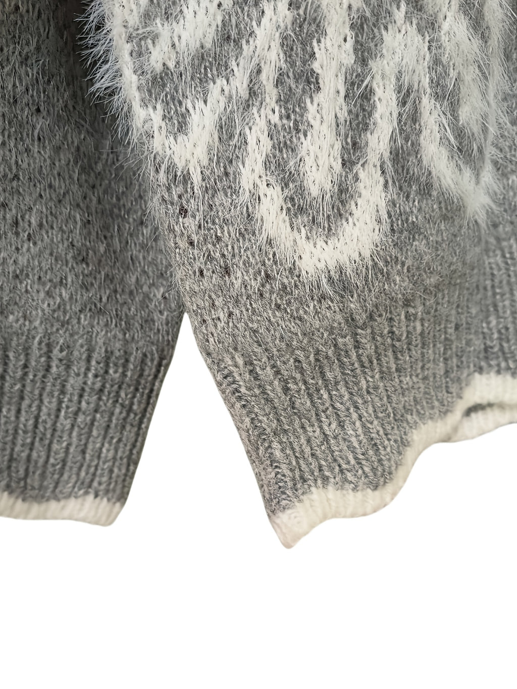 Close-up of a gray knitted sweater with white pattern on a white background