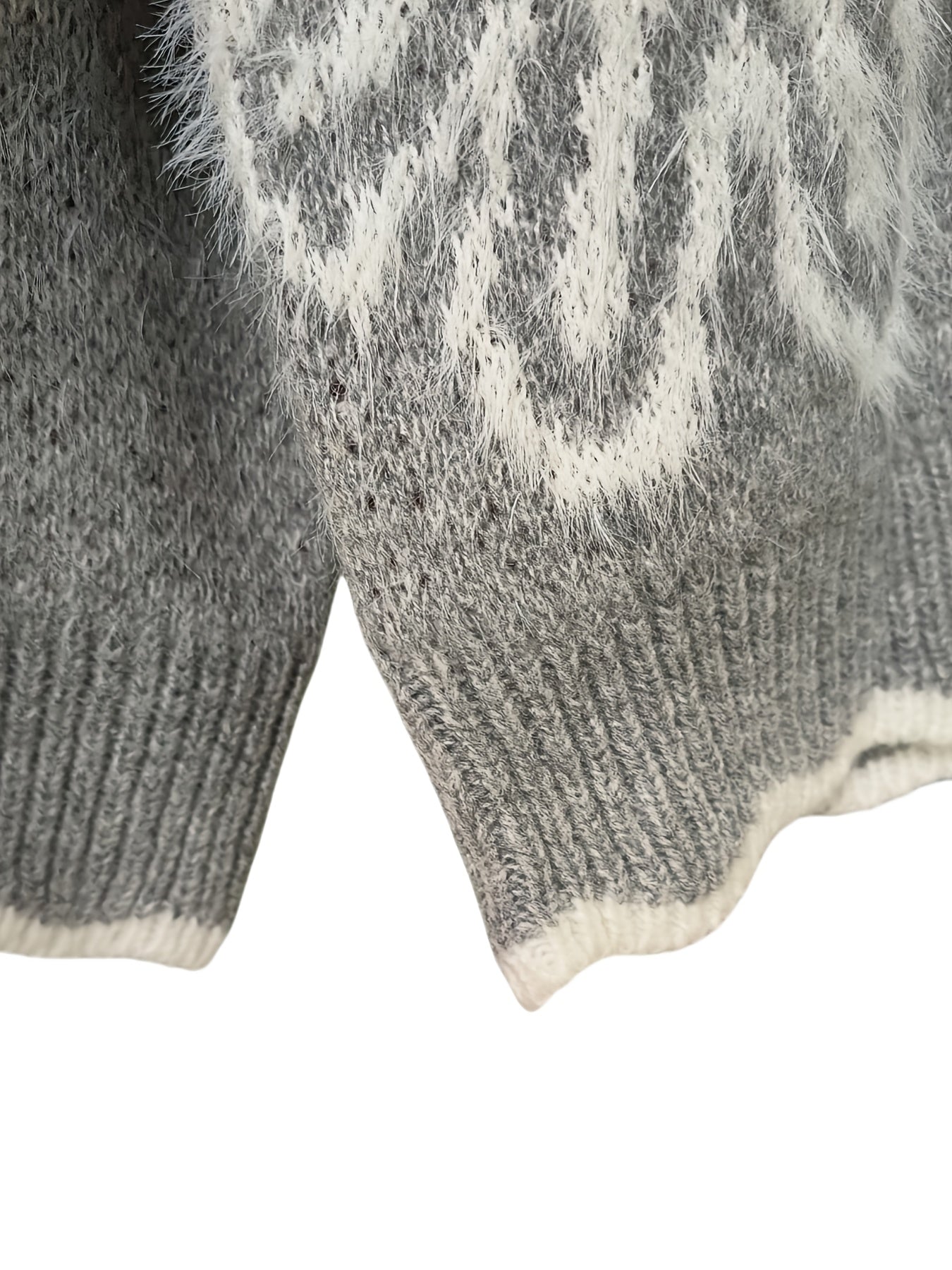 Close-up of a gray knitted sweater with white pattern on a white background