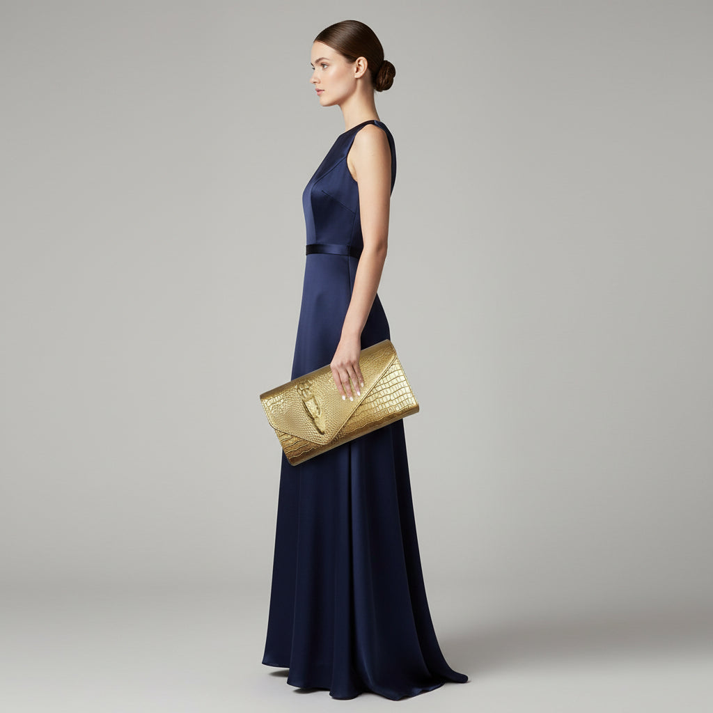 Gold clutch with crocodile texture held by a hand