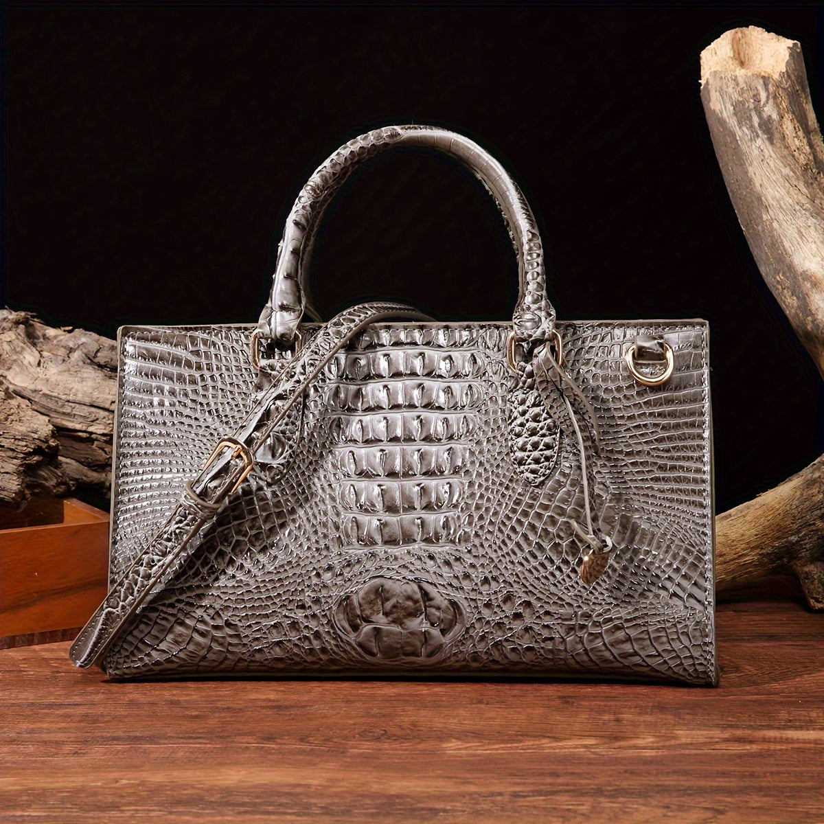 Gray textured handbag on a wooden surface with dark background