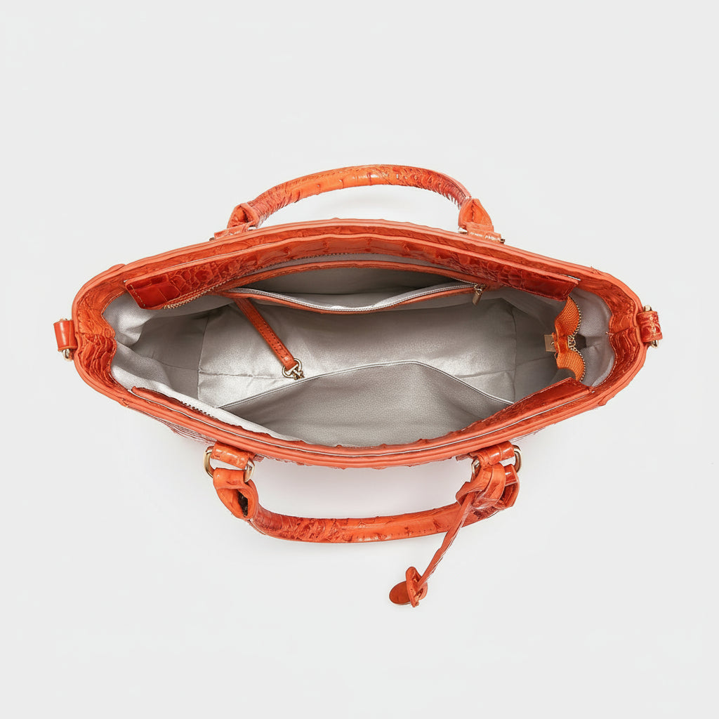 Orange handbag with silver interior on a white background