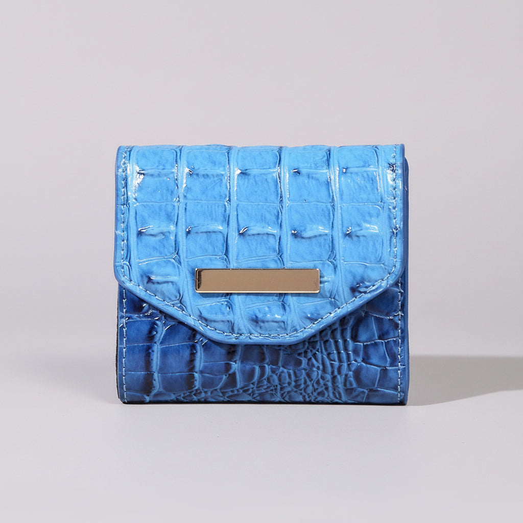 Blue textured wallet with a gold tag on a light surface