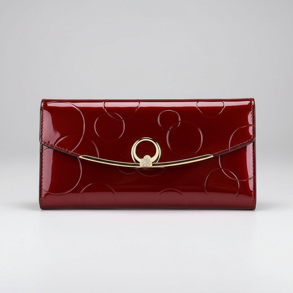 Red wallet with gold accents on a surface with a magazine underneath