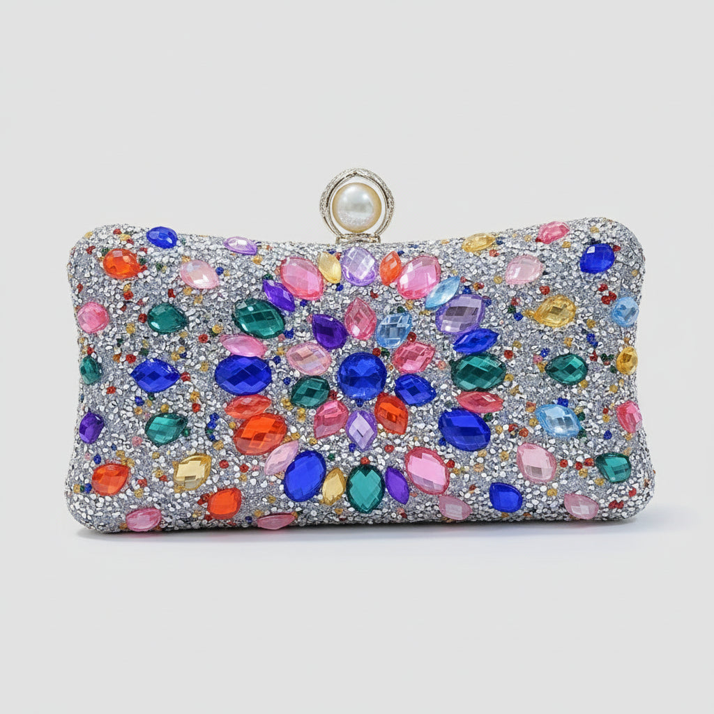 Hand holding a colorful gemstone clutch against a neutral background