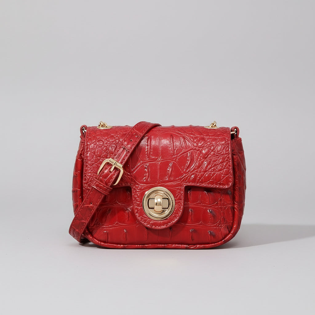 Red textured handbag on a wooden surface with a dark background