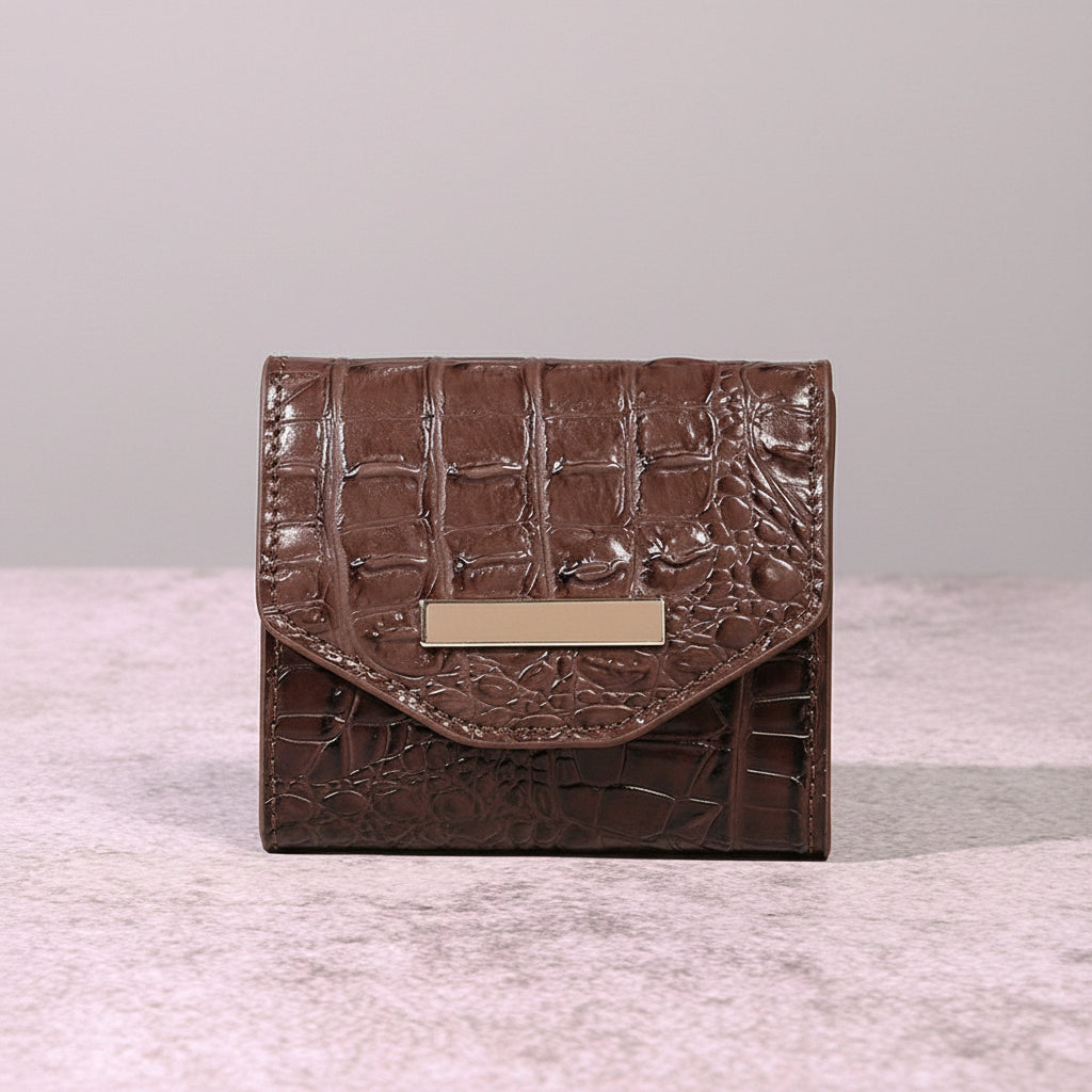 Brown textured clutch bag on a textured surface with a dark background