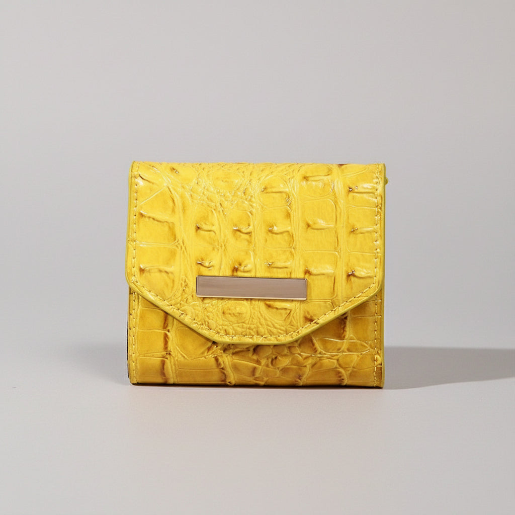 Yellow textured clutch bag with a wooden box on a textured surface