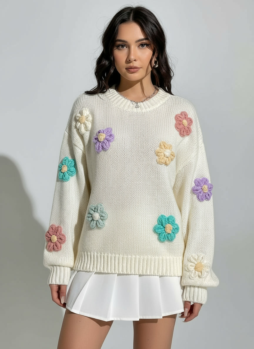 Person wearing a cream sweater with colorful flower patterns against a white background