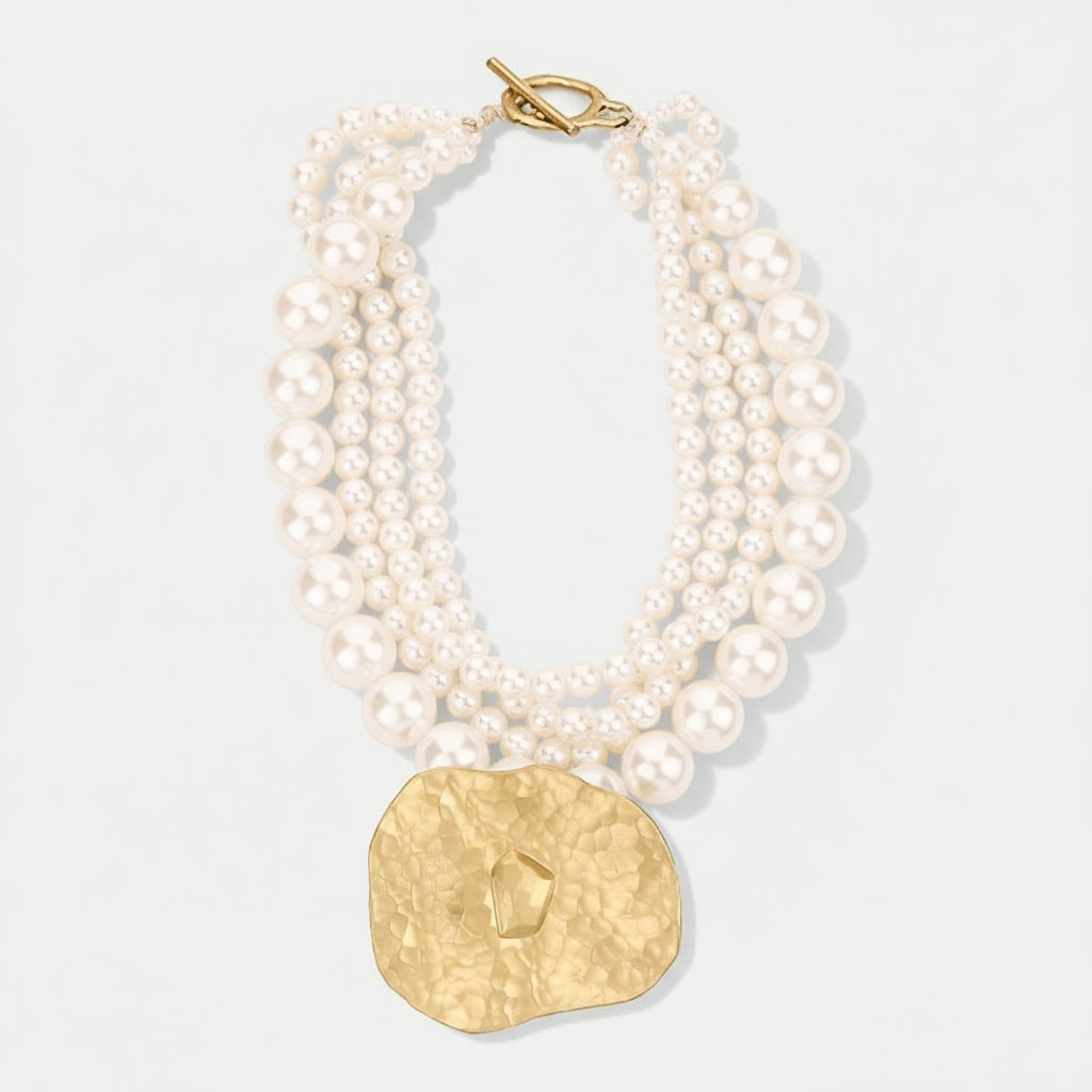 Pearl necklace with a gold clasp on a light gray background