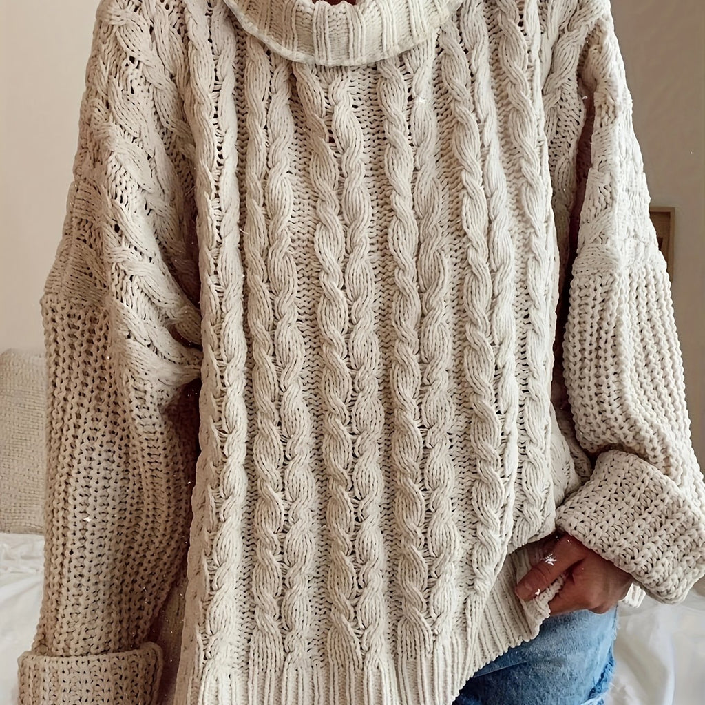 Beige cable knit sweater worn by a person, with a neutral background
