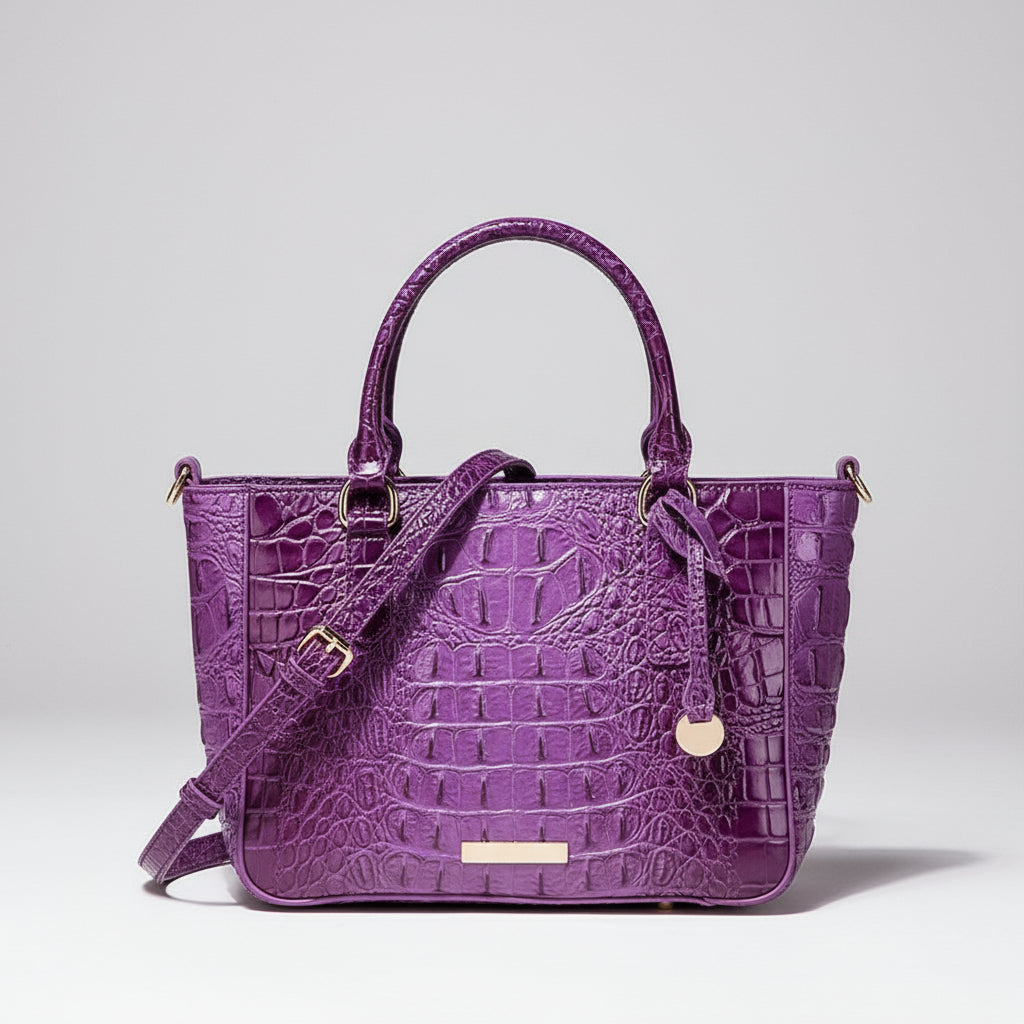 Purple crocodile-patterned handbag with a matching strap on a dark background
