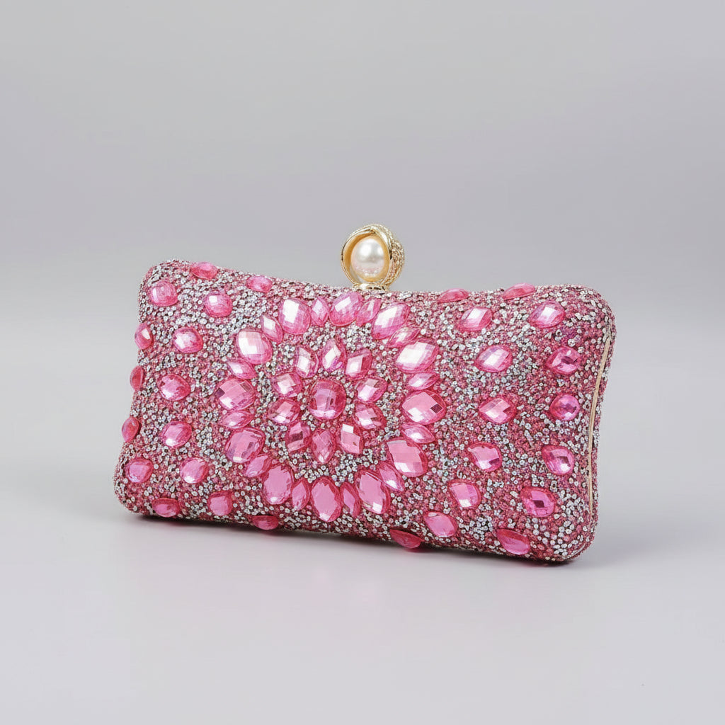 Pink beaded clutch held by a hand against a neutral background