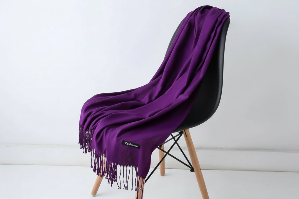 Purple scarf with fringe on a white chair against a light background