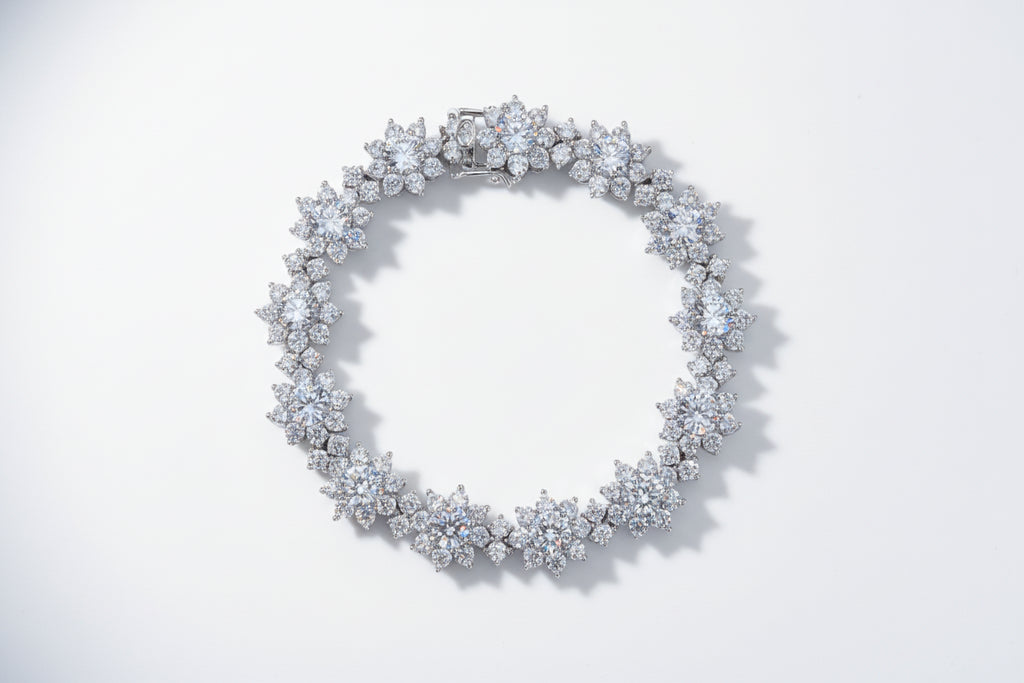 Silver bracelet with floral design on a light gray background