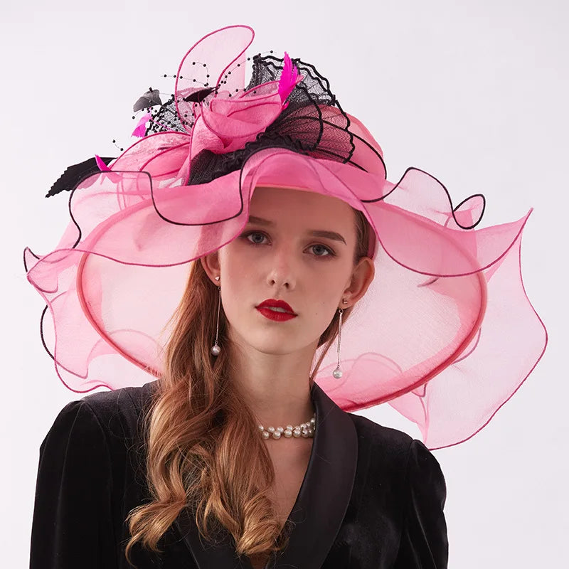 Woman wearing a large pink and black hat against a white background