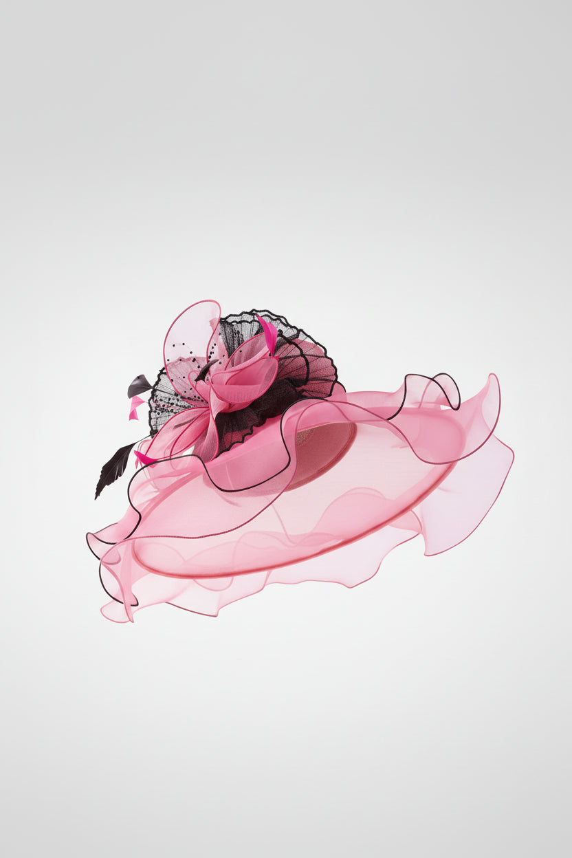 Woman wearing a large pink and black decorative hat on a white background