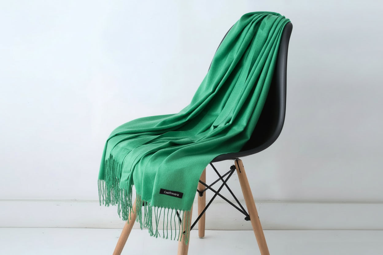 Green scarf draped over a white chair with a plant in the background