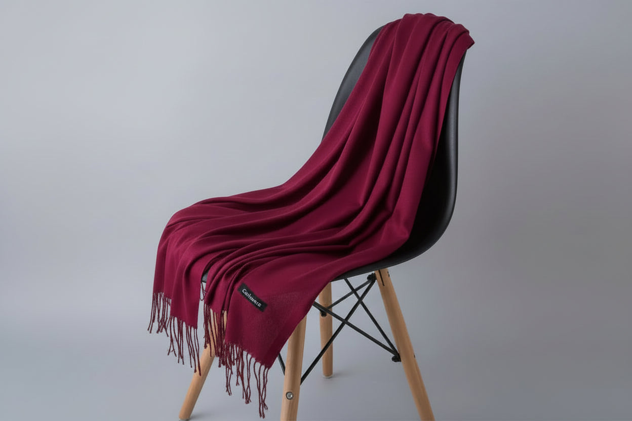 Red blanket draped over a white chair with a plant in the background