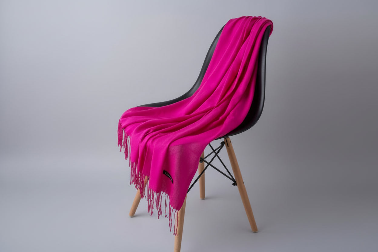 Pink scarf draped over a white chair with a plant in the background