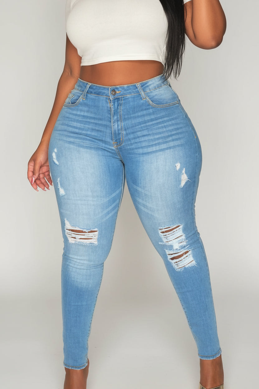 Person wearing blue ripped jeans and a white top indoors.