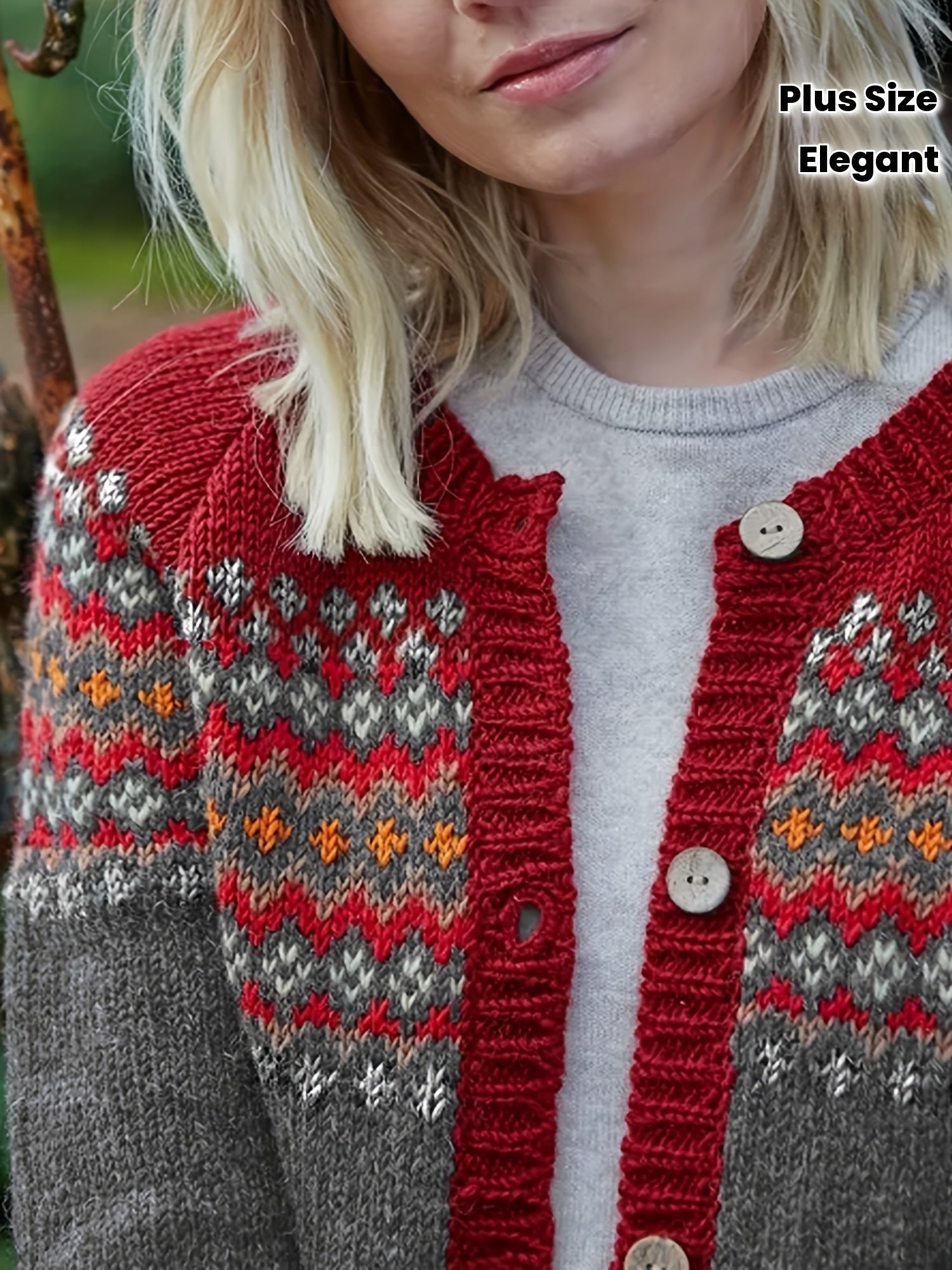 Person wearing a red and gray patterned cardigan with a blurred background