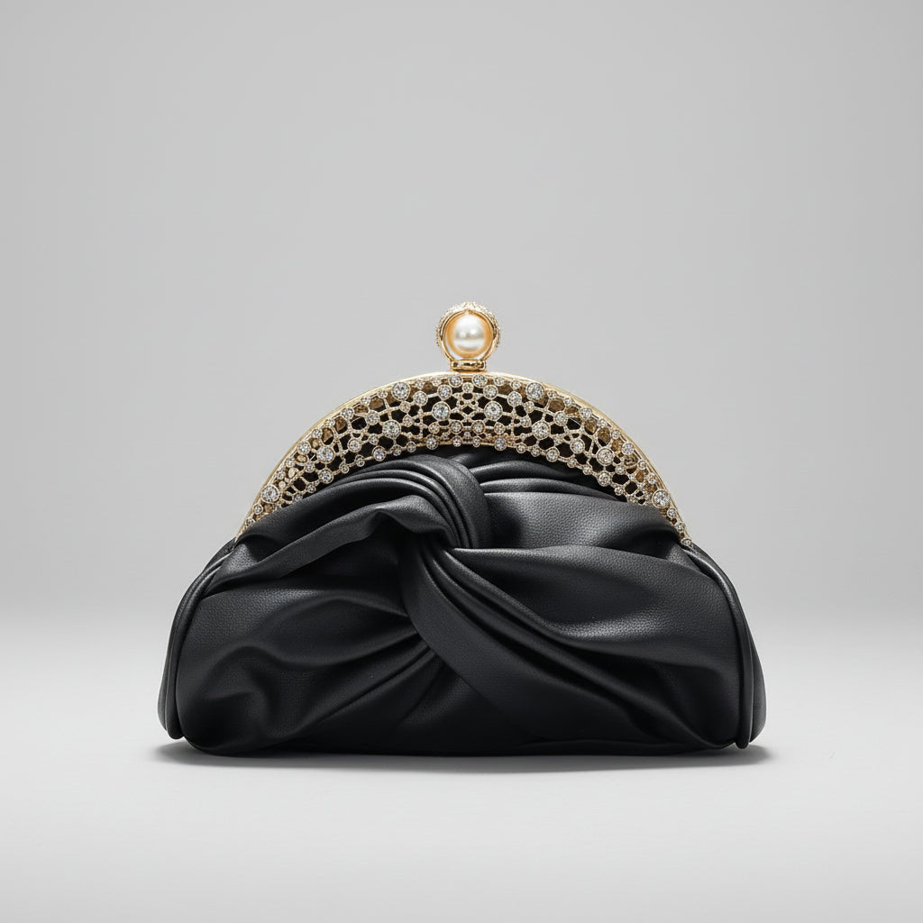 Black clutch with gold embellishments held by a hand against a neutral background