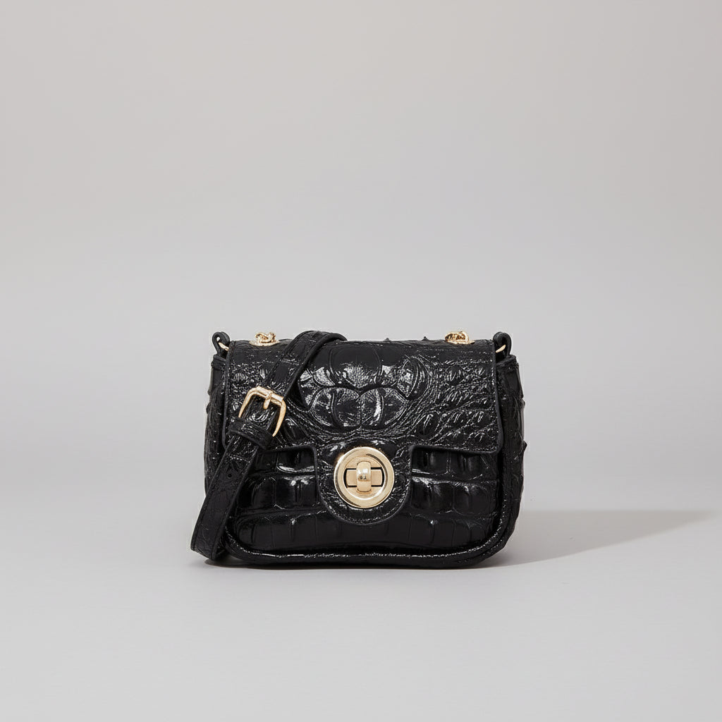 Black textured handbag on a wooden surface with a dark background