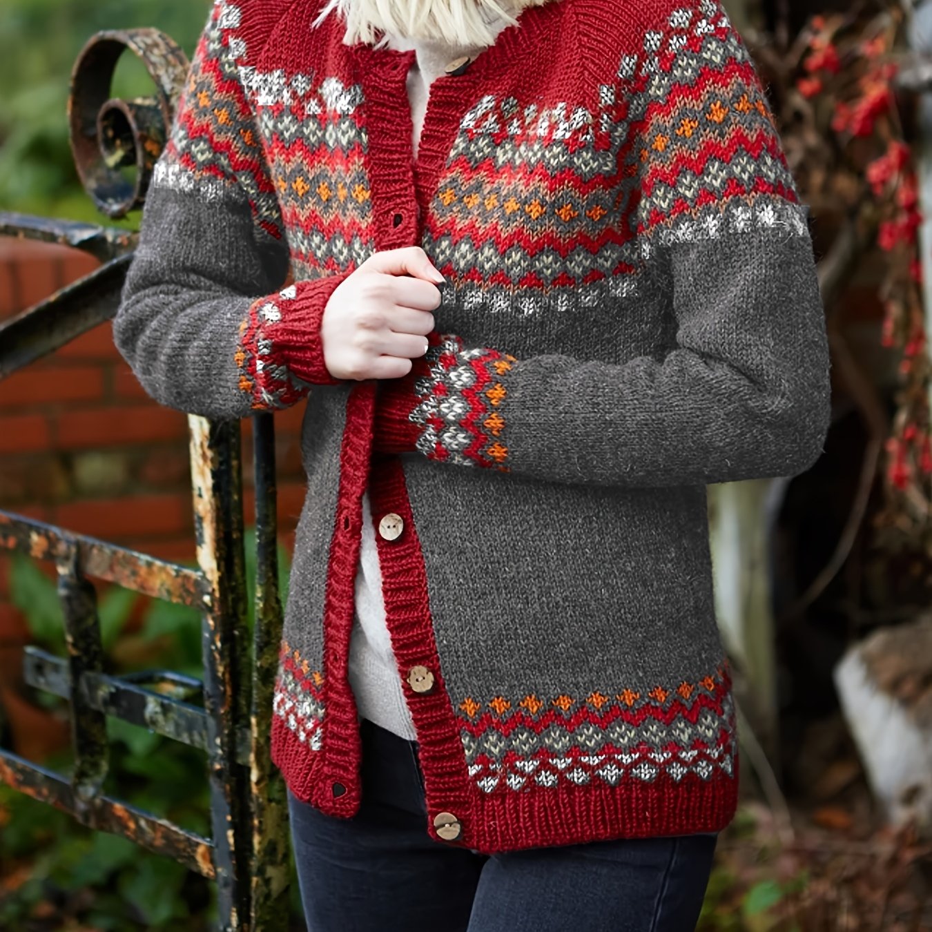 Person wearing a red and gray patterned cardigan in an outdoor setting