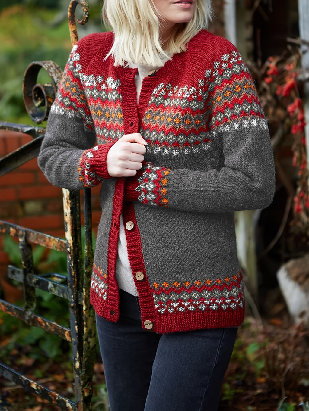 Person wearing a red and gray patterned cardigan outdoors