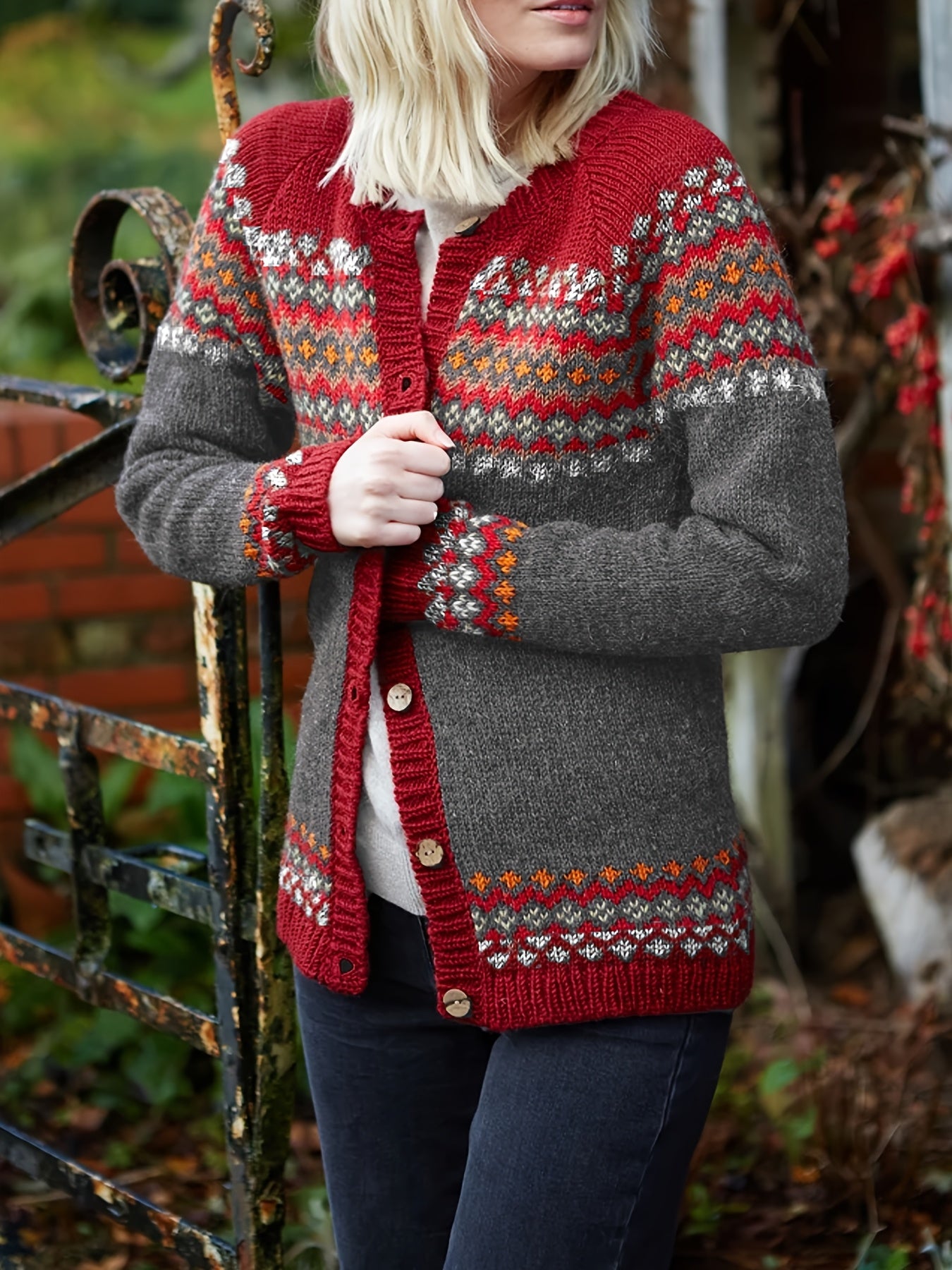 Person wearing a red and gray patterned cardigan outdoors
