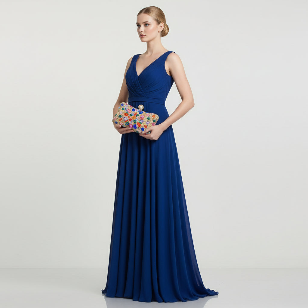 Multicolored gemstone clutch held by a hand against a neutral background