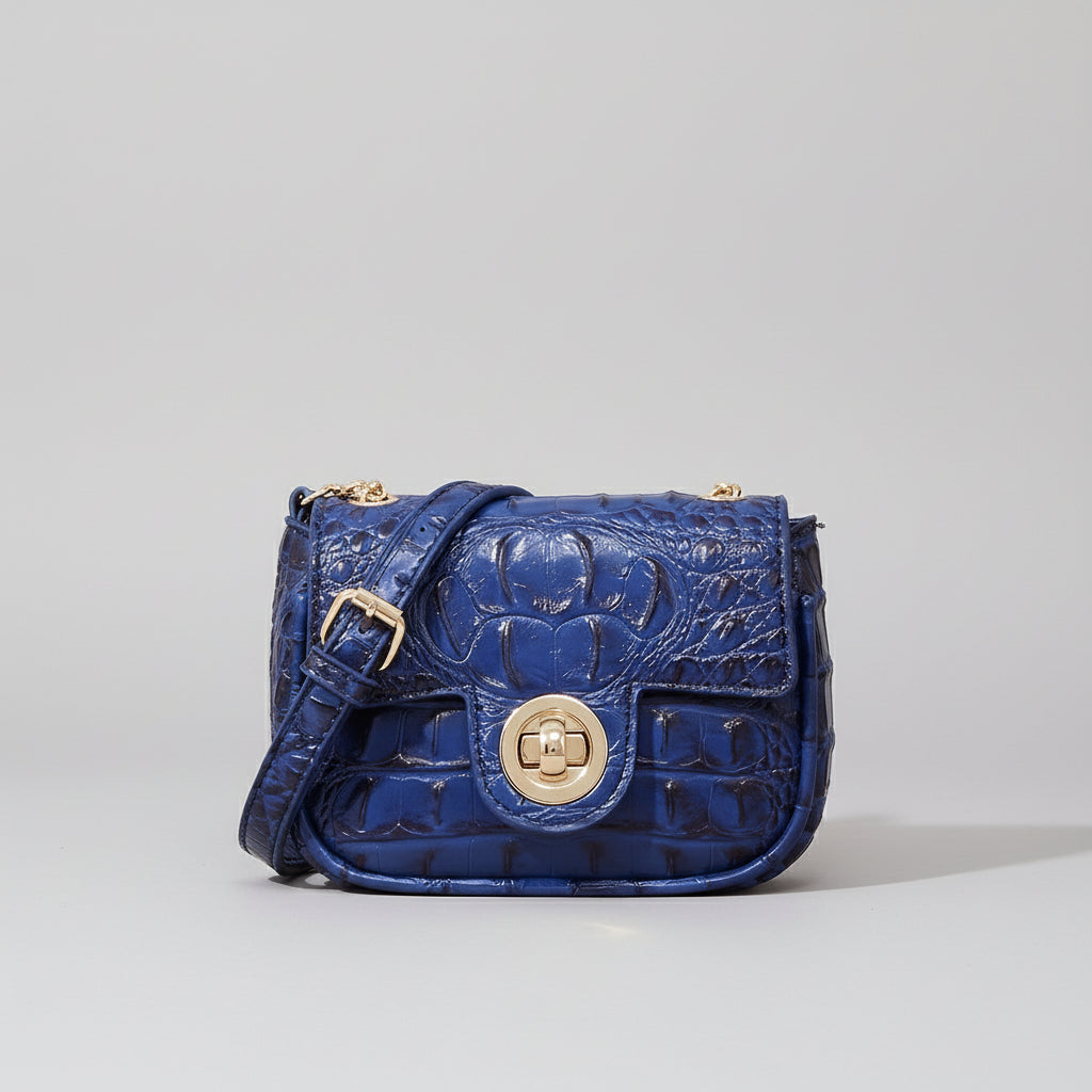 Blue textured handbag with gold buckle on a wooden surface